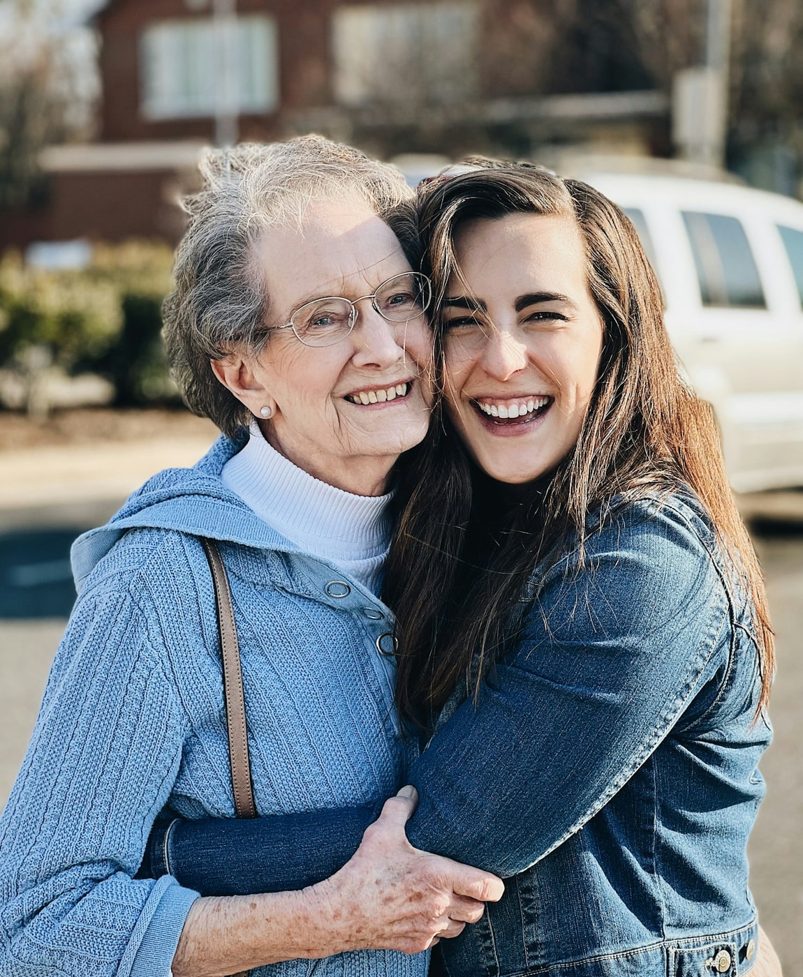 A grandmother and her granddaughter laughing, cheek to cheek